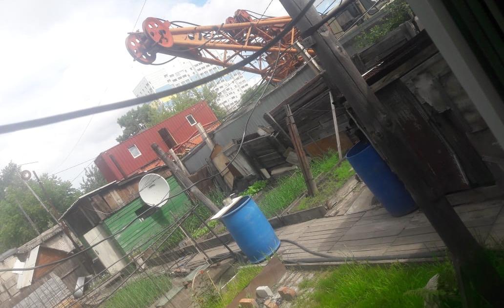 Строительный кран навис над огородом одного из частных домов в Барнауле